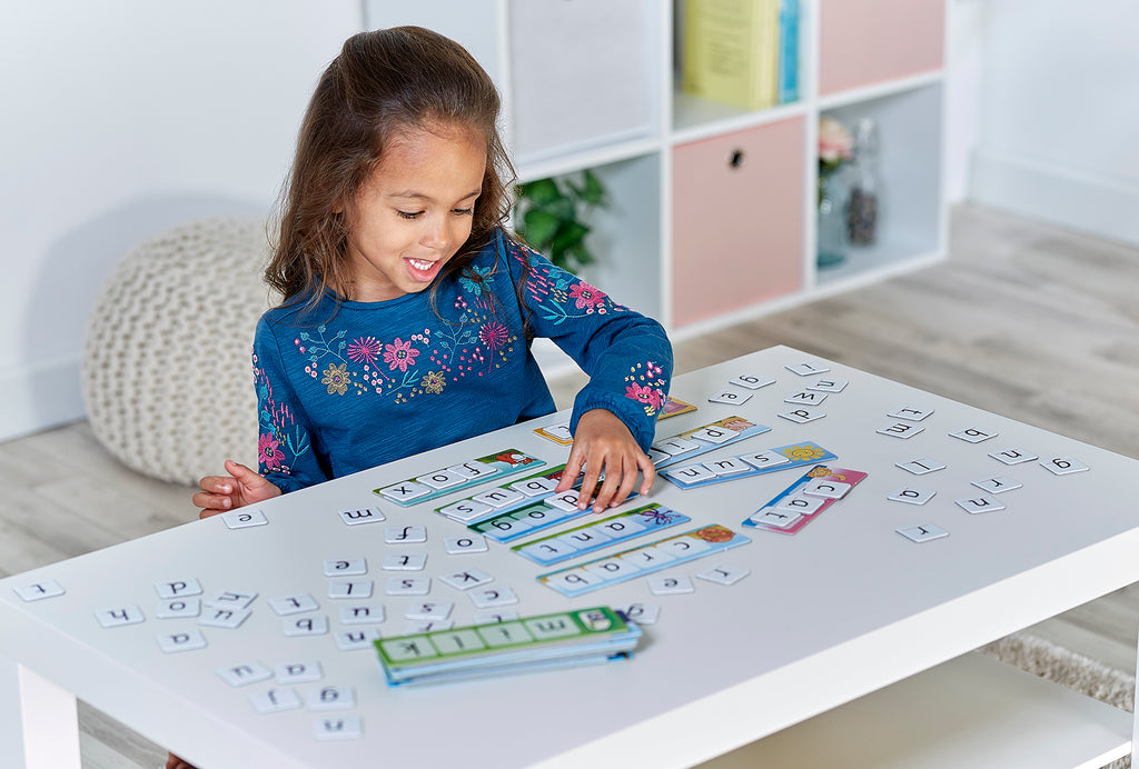 Child playing with educational toys on a table in a room with shelves and decor.