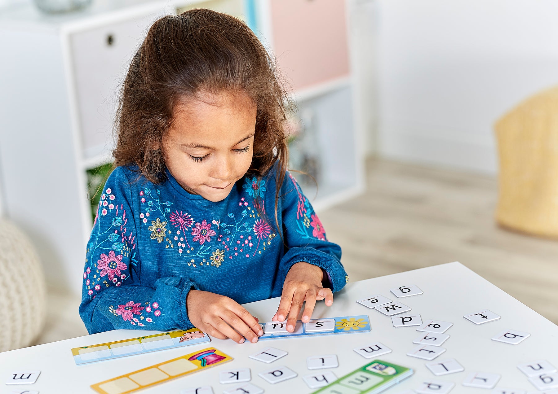 Child playing with educational letters and numbers on a table