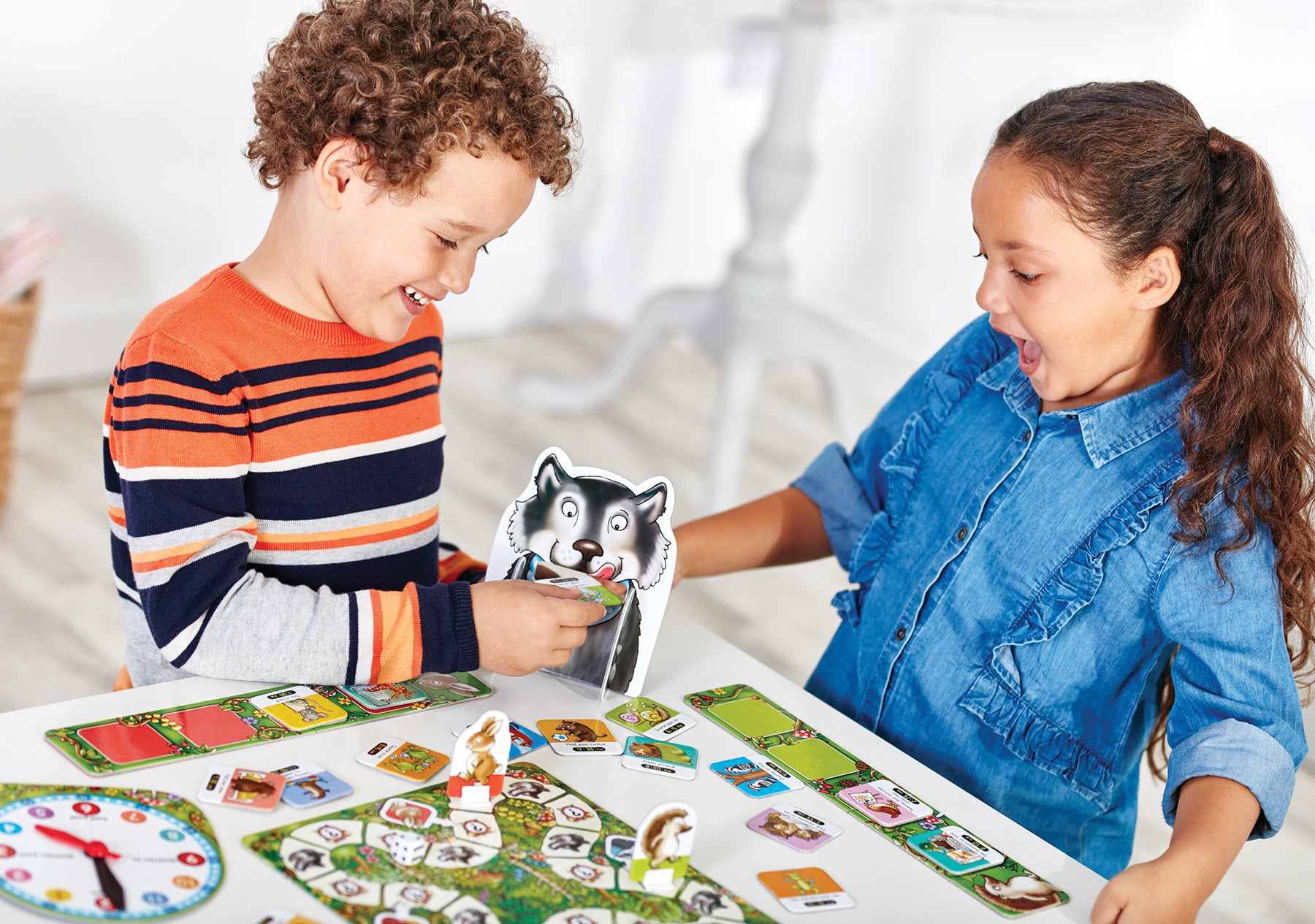 Two children playing with a board game on a table.