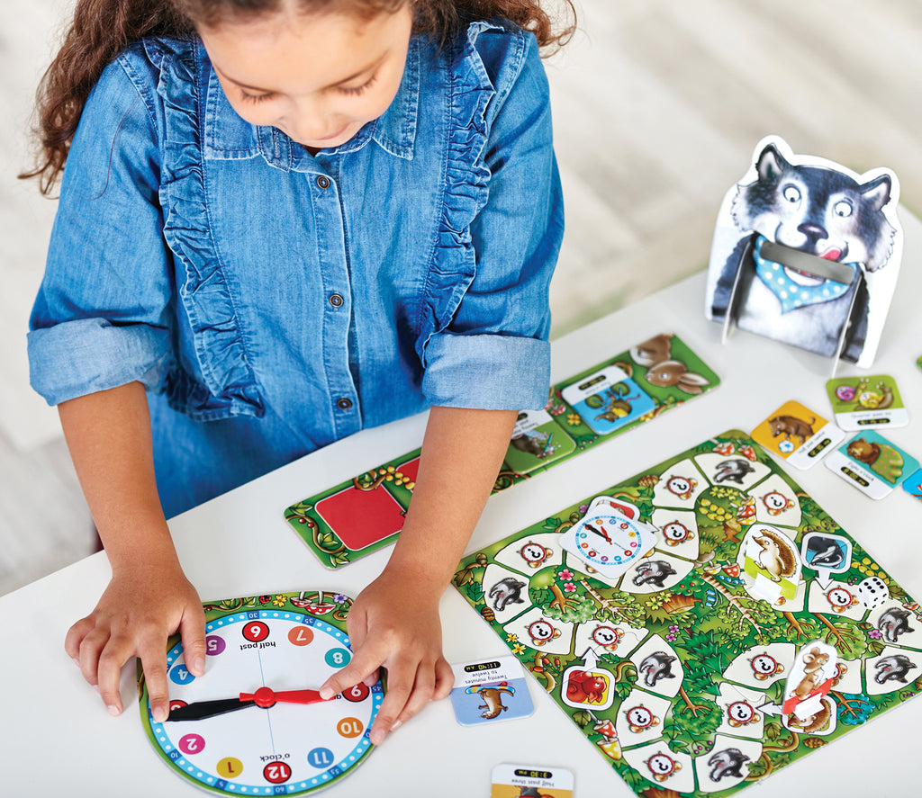 Child playing with a board game featuring animal cards and a clock