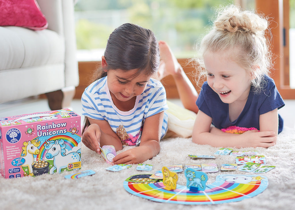 Two children playing with a craft kit on a carpeted floor.