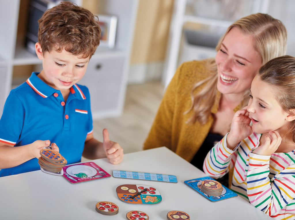 Family playing a board game together in a cozy living room.