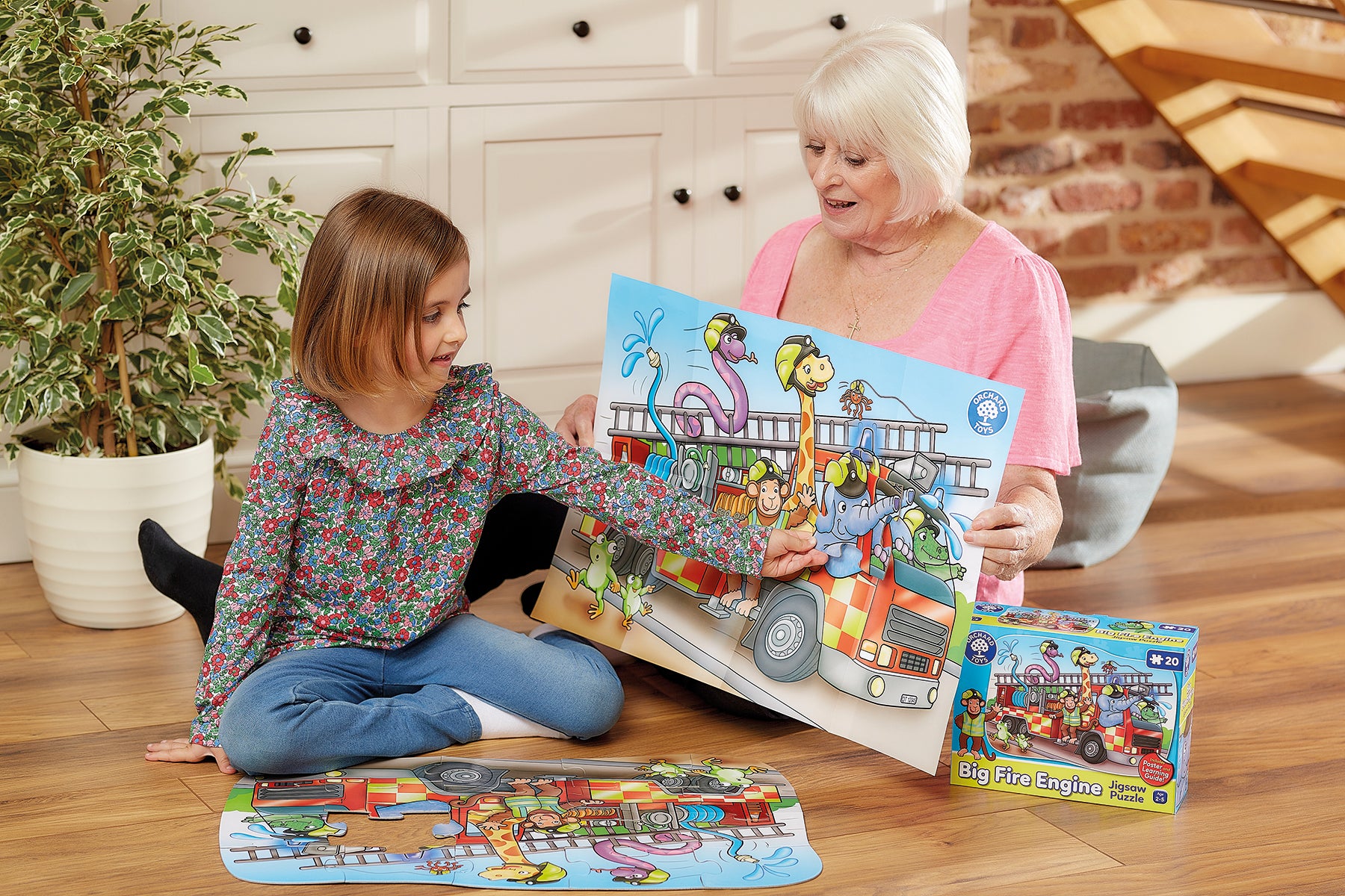 Grandmother and granddaughter playing with a children's puzzle on the floor.