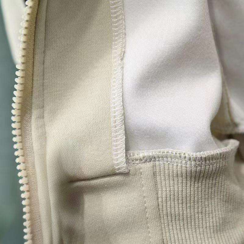 Close-up of a beige fabric with a zipper and stitching detail.
