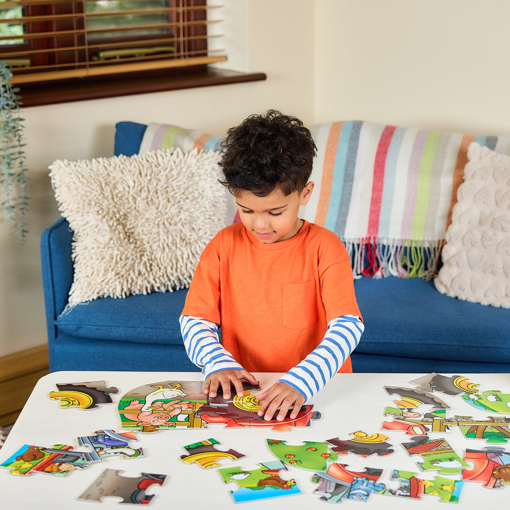 Child playing with a puzzle on a table in a living room.