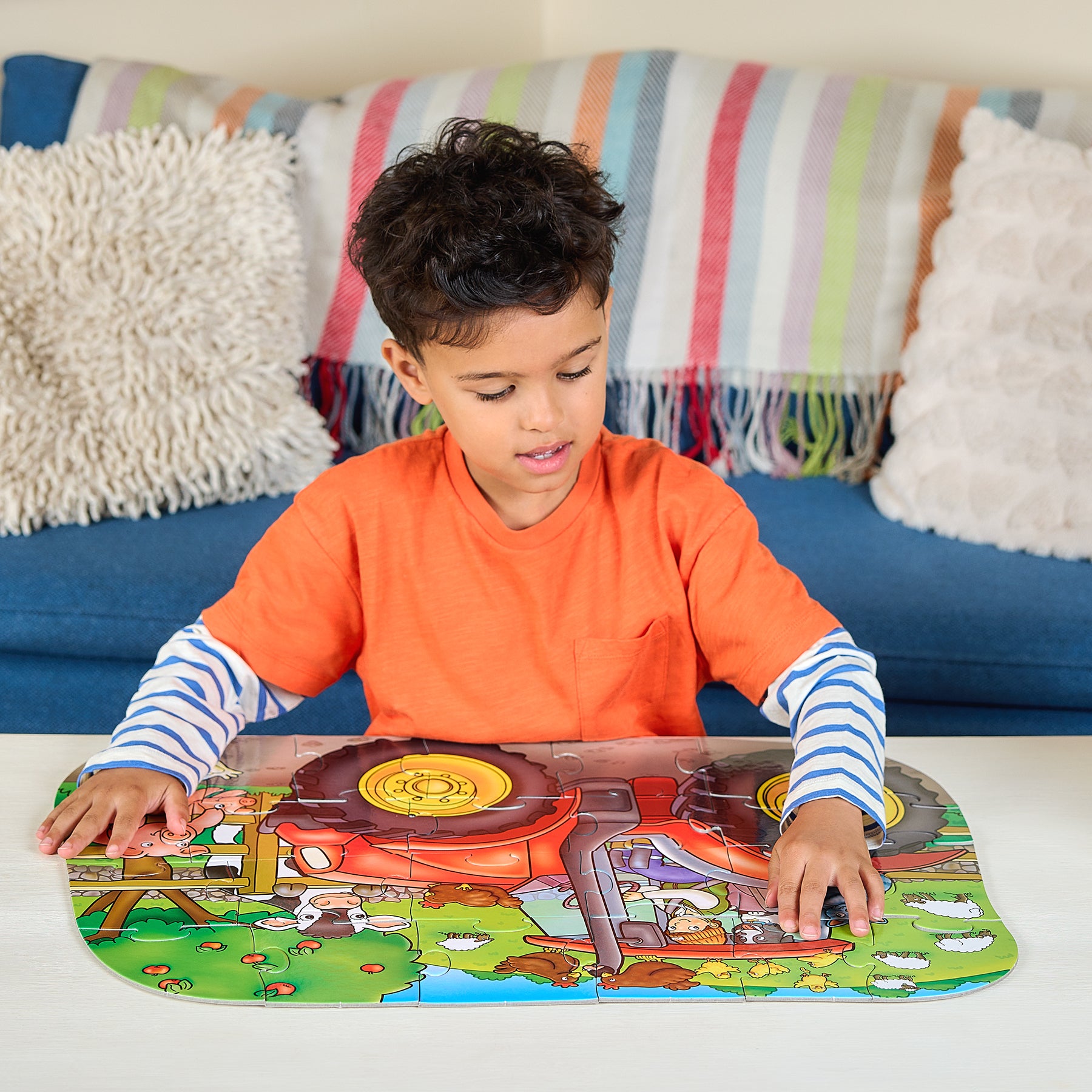 Child playing with a colorful farm-themed puzzle on a table.