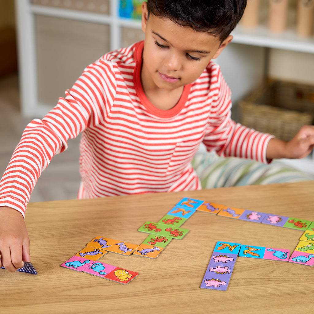 Child playing with colorful card game on a wooden table