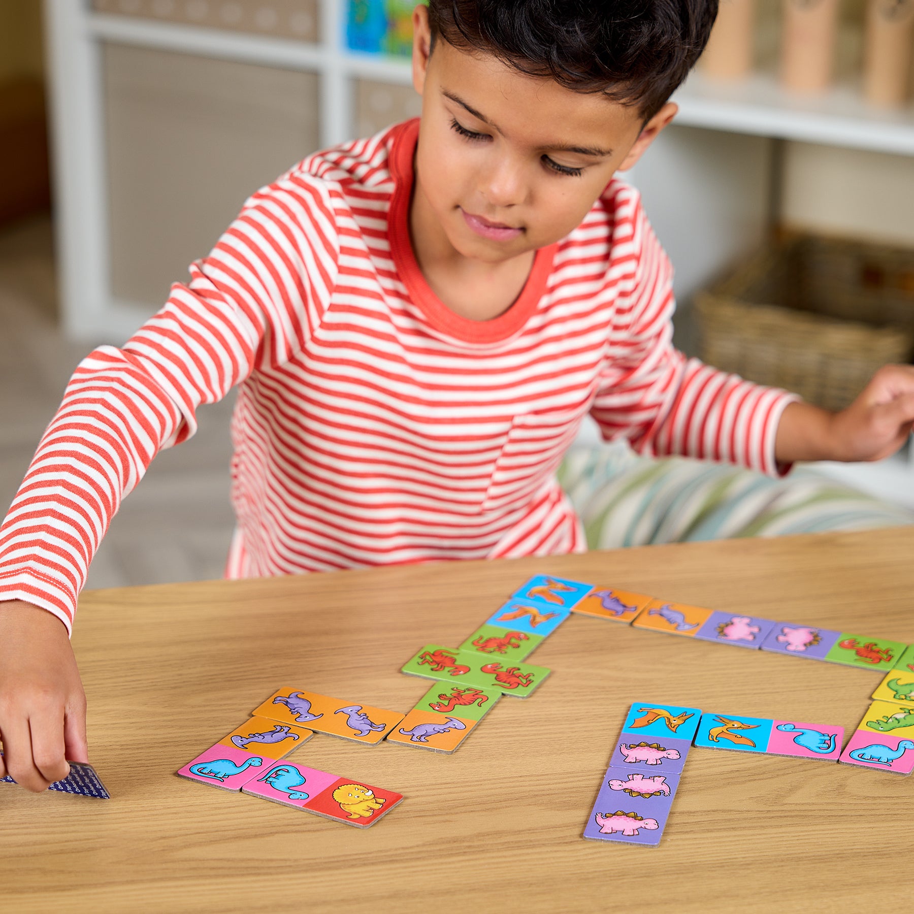 Child playing with colorful card game on a wooden table