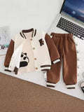 Children's brown and beige jacket with panda design and matching pants on a desk with a laptop.