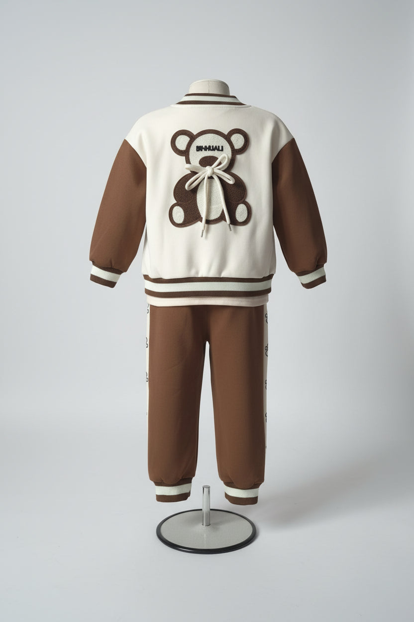 Brown and white tracksuit with teddy bear design on a mannequin against a gray background